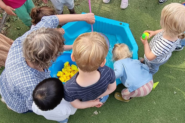kinderen buiten spelen vijver met badeendjes